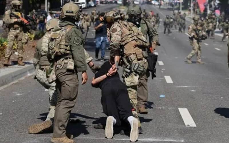 Las autoridades de EUA han aumentado las detenciones de migrantes Miembros de la Guardia Nacional deteniendo a una persona en Los Ángeles