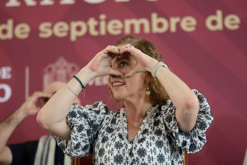 Beatriz Gutiérrez Müller, esposa de Andrés Manuel López Obrador. Gutiérrez Müller posando con gesto de corazón en un evento del gobierno de México.