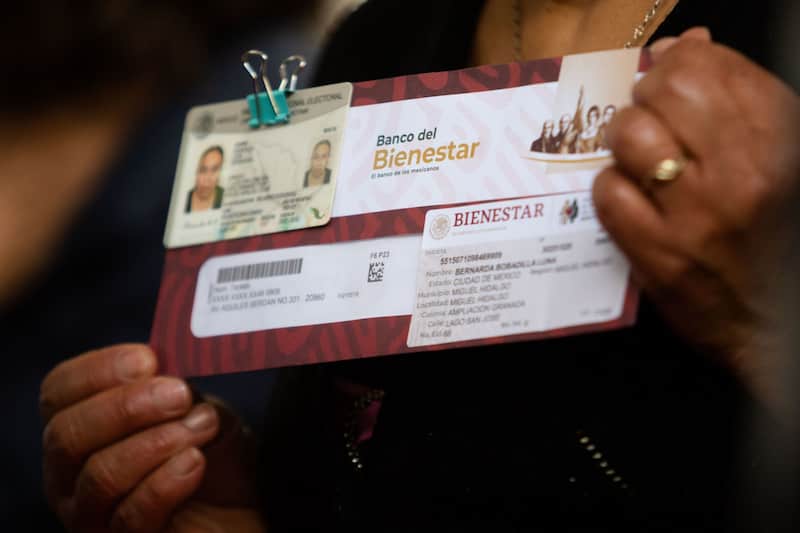 Personal de la Secretaría del Bienestar le toma una foto a un hombre que acaba de recibir su tarjeta del Bienestar. Imagen promocional