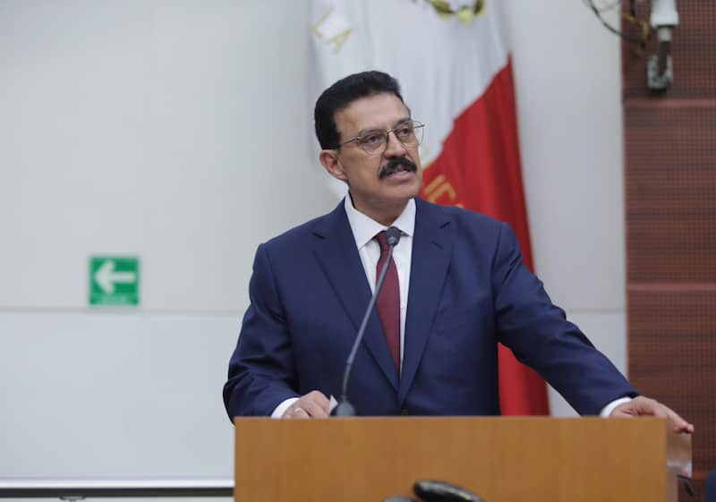 El senador de Morena, Carlos Lomelí. Carlos Lomelí hablando desde un podio en un evento.