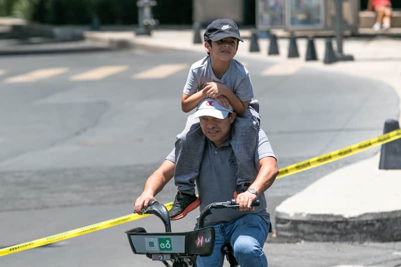 Papá en compañía de su hijo. Un padre en bicicleta junto a su hijo en el Día del Padre.