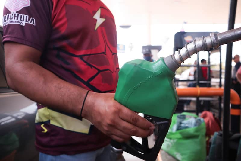 Hombre cargando combustible Imagen de un hombre cargando gasolina en una gasolinera.