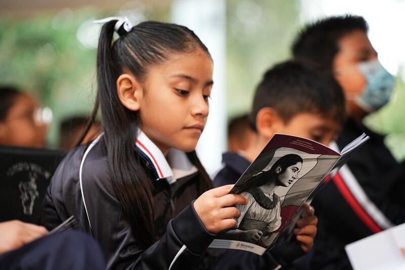 Niña leyendo Cartilla de las Mujeres