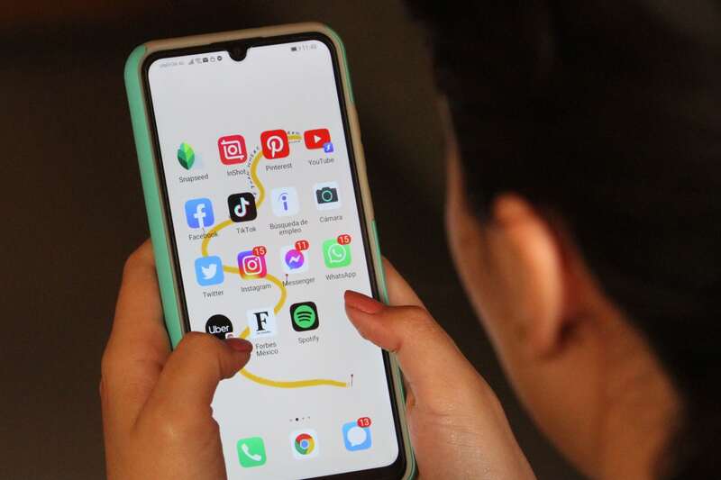 La mayoría de las personas que utilizan redes sociales las utilizan para mantenerse en contacto con sus amigos y familiares, según encuesta. Una mujer ve su celular con el menú de sus redes sociales