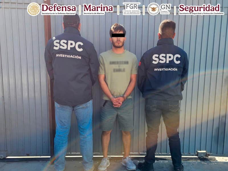 En dos acciones diferentes, el Gabinete de Seguridad detuvo a tres individuos en Tijuana. Imágen de uno de los presuntos delincuentes custodiado por dos agentes de seguridad.