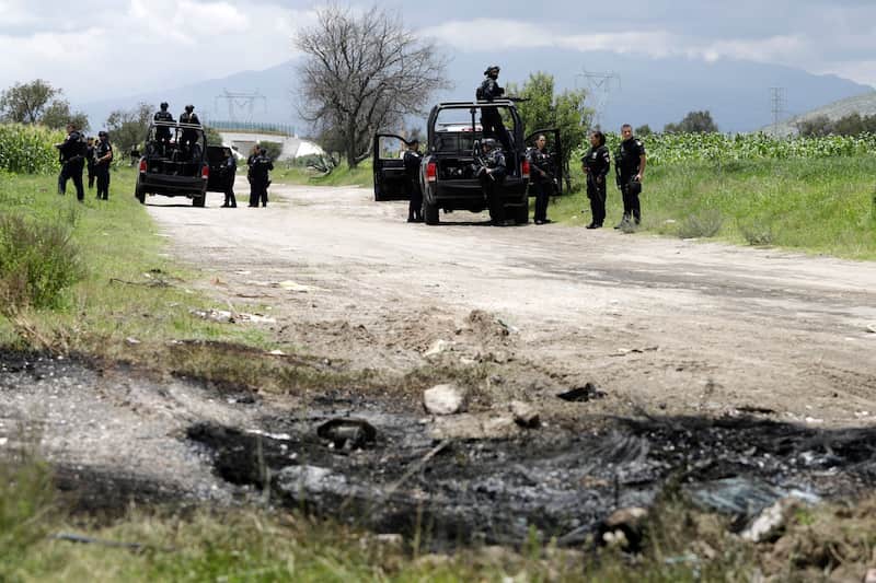 Policía federal resguarda la zona y dos camionetas de Seguridad Física de Pemex que fueron incendiadas por presuntos "huachigaseros". Toma clandestina de huachicol