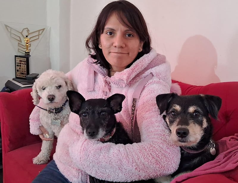 Mujer posa feliz con sus perritos