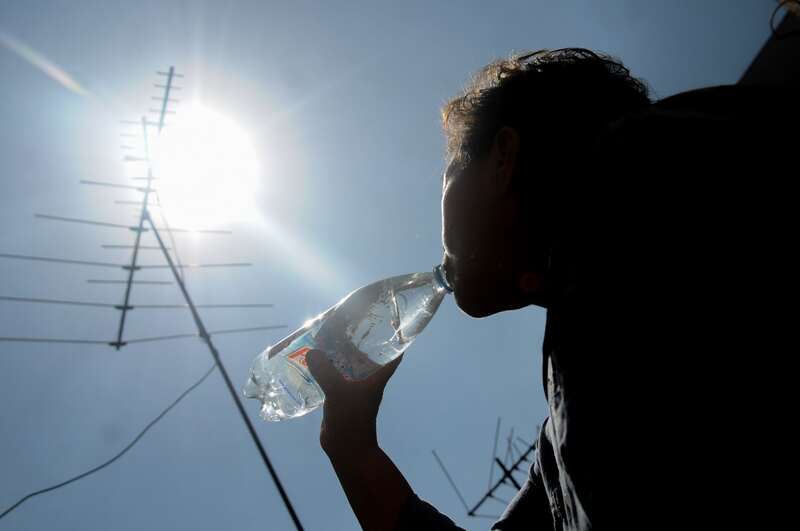 Persona en temporada de calor. Una persona tomando agua durante temporada de calor.