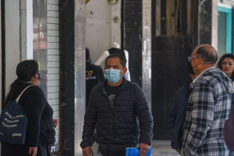 Autoridades de salud recomiendan el uso de cubrebocas y el lavado frecuente de manos como medidas de prevención. Un hombre caminando en espacios públicos mientras usa un cubrebocas.