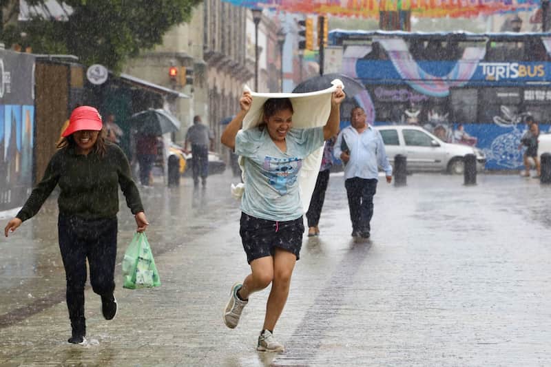 En Michoacán y Guerrero podría golpear la primera tormenta tropical Personas corren para huir de la lluvia