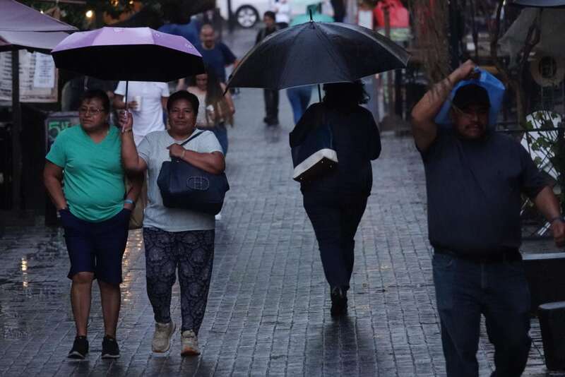 Tormenta tropical traerá lluvia en estos estados Personas con sus paraguas caminando en la calle de la cdmx